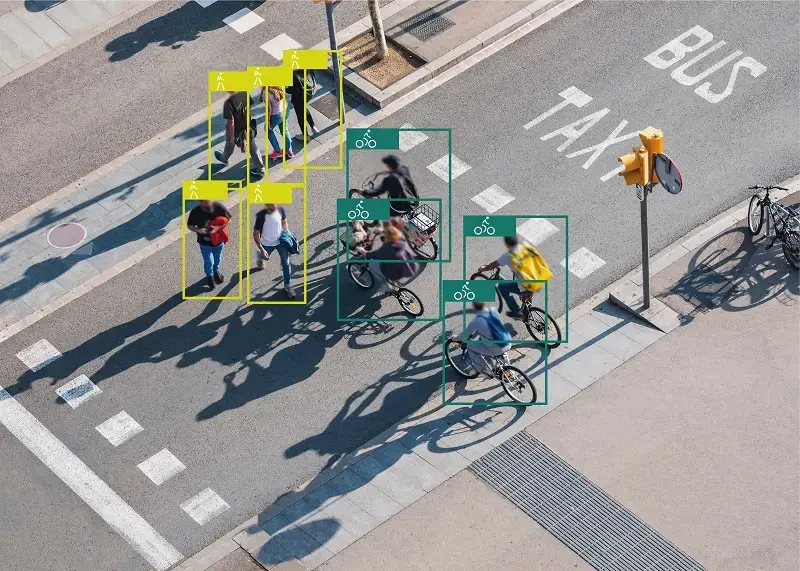 AI-powered computer vision detecting and classifying pedestrians and cyclists on a street using bounding box object detection